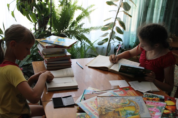 Девочки ставят печати на книгах Девочки ставят печати на книгах