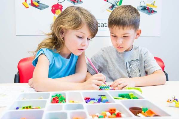 Мальчик с девочкой собирают конструктор Lego Мальчик с девочкой собирают конструктор Lego